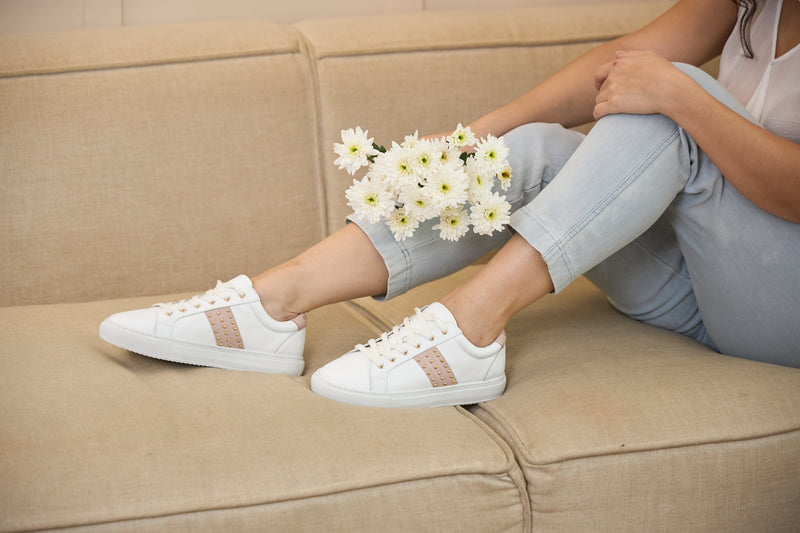 white leather upper with a gold studded pastel pink stripe and pastel pink heel detail